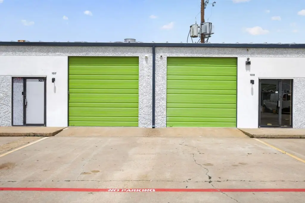 Small warehouse for rent in Houston with green roll-up doors and private office entrance doors.